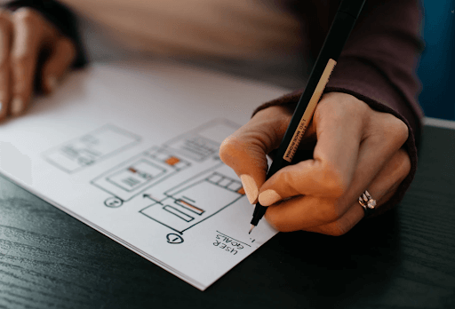 Woman writing user goals with an outline on a sheet of paper
