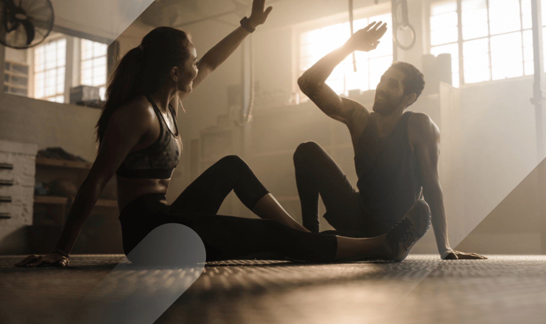 man and woman giving each other a high five after the training session in gym
