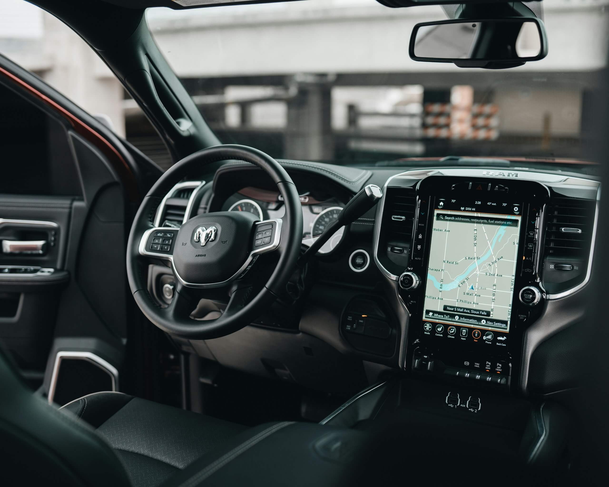 Photograph of a car steering wheel, dashboard and center console.